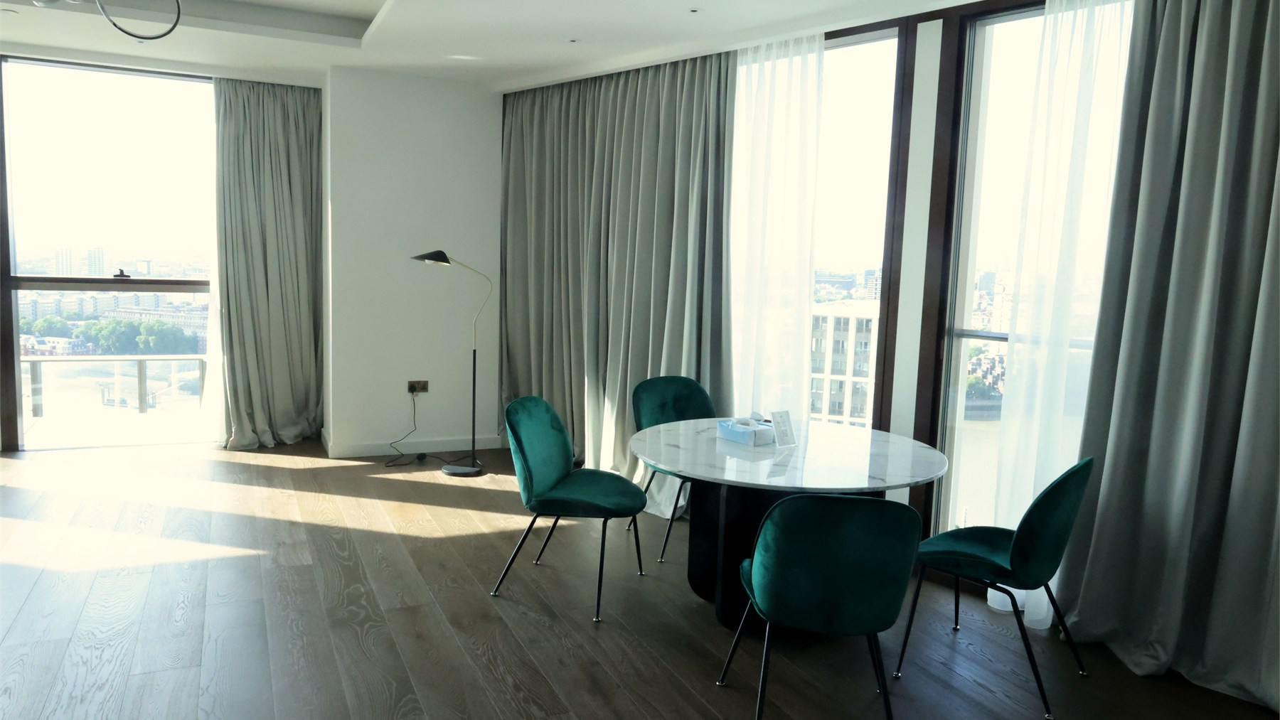Dining area with curtains, fitted flooring and city-facing glazing
